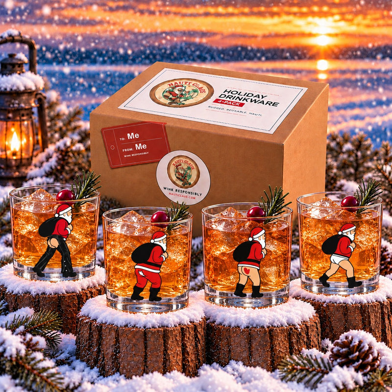 Holi-Bottom gift set: four Nauti Claus rocks glasses with cheeky rear views of Santa beside the gift box at a snowy lakeside sunset